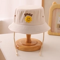 Dettaglio cappello alla pescatora beige per bambini con ricamo smile e cordino antivento - 52cm (2-5 Anni) / Beige