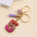 Detail of resin number 5 keychain with colorful sequins, purple tassel and golden clasp - Number 5