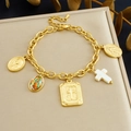 Gouden armband met religieuze medailles en kruishangers op een beige kussen - Gouden Armband