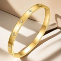Detail of gold titanium steel bracelet with sparkling diamond floral patterns and clasp - Clover Bangle (TT0096) / Gold