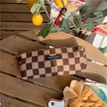 Close-up of a brown checkered corduroy pencil case on a wooden bench with lemon decor - Dark Brown Checkerboard