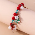 Close-up of Christmas beaded bracelet with reindeer and tree charms on pink stand - Red/Green/White Beads-Multi Charms Set