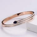 Detalle de brazalete de serpiente en oro rosa con doble hilera y piedra gota azul - Oro rosa