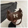 Detail of dark brown crescent bag with silver metal bow and knotted leather strap - Brown