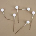 Macro view of six white foam decorative berries on brown stems for DIY crafts and decor - White