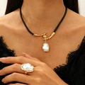Detailed macro view of gold-toned baroque pearl pendant on a black cord leather necklace - Gold Branch White Pearl Leather Cord 2-Piece Set
