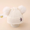 Detailansicht der Winterstrickmütze mit zwei Kunstfellbommeln und Einhorn-Stickerei - Einheitsgröße (3-10 Jahre) / Weiß