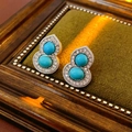 Detailopname van vintage oorbellen met turkoois inlegwerk op groen fluweel - Fleskalebasvormige Oorknopjes (Zilver-Blauw) / Zilveren naald