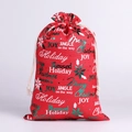 Detail of red linen Christmas gift bag with golden Merry Christmas text and drawstrings - Red Letter