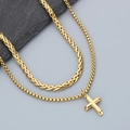Detailed close-up of golden cross pendant with Cuban and wheat chain necklaces - Gold