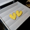 Gros plan sur des boucles d'oreilles cœur en émail jaune et bordure dorée sur velours - Tige en Argent - Jaune