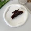 Detailed top view of an amber hair claw clip with colorful rhinestones on a white tray - Ear Design With Black Teeth Claw Clip / Brown