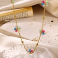 Golden necklace with colorful beaded flowers on a warm cream fabric background - Colorful Beaded Flower