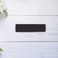Elastic solid black yoga headband in minimalist style on white wooden background - Black
