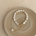 Detailed view of baroque pearl bracelet with gold beads on ceramic tray background - Gold Bean Baroque Pearl Bracelet