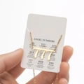 Collier doré chiffre des anges avec pendentif 777 sur une carte de présentation - 777 / Or