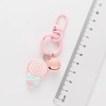 Lollipop keychain detail showing 9.5cm length measurement with a ruler and pink bell - Pink