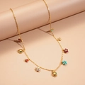 Macro view of gold chain necklace featuring colorful ladybug and flower charms with cubic zirconia - Necklace-Multicolor