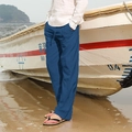 Pantalon homme en lin bleu avec cordon de serrage, présenté dans un décor de plage décontracté - Bleu ciel