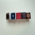 Macro detail of five miniature vintage-style hair clips in diverse antique book colors - 10# Red Coffee Book Clip