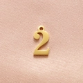 Macro shot of gold number 2 charm with brushed texture for DIY jewelry making - Gold Number 2