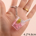 Detail view of 4.2x4.8cm mini fruit tea keychain featuring pink liquid and ice cubes - Pink