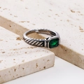 Macro detail of a silver twist band ring with a rectangular emerald green gemstone - Silver/Green Zirconia