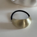Detalle del adorno de metal dorado mate en una goma de pelo negra de alta elasticidad - Banda Elástica de Aleación Curvada / Oro Mate (Acabado Cepillado)