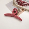 Macro detail of large matte dark red hair claw clip with a sleek streamlined design - Cross / Raspberry Pink
