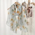 Light blue floral voile scarf with yellow and green flowers hanging on a wooden hanger - Light Blue Yellow Green Floral