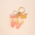 Pink resin letter W keychain with gold glitter stars, butterfly pendant, and tassel - Letter W