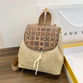 Mochila de paja con patrones de azulejos retro y detalle de flecos sobre madera - Caqui Estampado