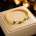 Detail of gold-plated bangle featuring four emerald-green heart-shaped zircon stones - Green