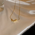 Primer plano de collar de acero de titanio dorado con cinco cuentas facetadas - Collar De Cadena De Bolas Dorado