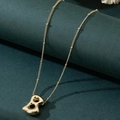 Collana con ciondolo lettera B a palloncino in oro lucido su elegante sfondo verde scuro - Lettera B