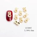 Golden rabbit ear pearl nail charms set with one piece displayed on red nail - LF2007 Gold Pearl Rabbit