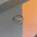 Detailopname van een zilveren ring met zirkonia op een grijs fluwelen display - Vervlochten Ontwerp (Zilver)