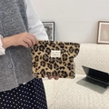 Cute leopard print plush cosmetic bag shown by model in cozy living room - Yellow Leopard
