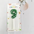 Green dinosaur number 9 birthday candle with white dots and plastic stand in packaging - Number 9