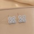 Detailed close-up of clover stud earrings with sparkling cubic zirconia on a textured surface - Silver Stud Earrings (557)