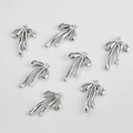 Dettaglio macro di ciondoli a fiocco placcati oro 14k con zirconi lucenti per gioielli DIY - 1 Pezzo (19*12.7mm) / Argento