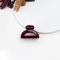 Detail shot of glossy wine red resin hair claw clip on a minimalist white ceramic plate - Jelly Mini Claw - Semi-circle Wine Red