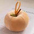 Porte-clés en peluche pêche avec feuille verte posé sur un fond de magazine vintage - Pomme Marron