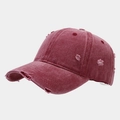Dettaglio del cappello da baseball bordeaux slavato con bordi sfrangiati e usurati - Borgogna