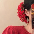 Detail of red floral hair comb and matching pearl drop earrings on model in red sweater - Red Hair Stick Earrings Set