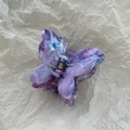 Macro detail of butterfly hair claw with purple marble texture and metal spring - Purple