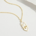 Primer plano de colgante hexagonal dorado con abeja, luna y estrellas sobre blanco - Blanco