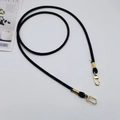 Close-up of black PU leather shoulder strap with gold spring clasps on white background - Black + Gold Hook