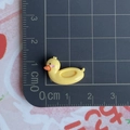Mesure détaillée de la taille d'un accessoire en résine canard jaune sur un tapis - Bouée Canard Jaune