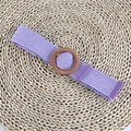 Dettaglio macro di cintura intrecciata elastica viola con fibbia tonda effetto legno - Fibbia Rotonda Viola